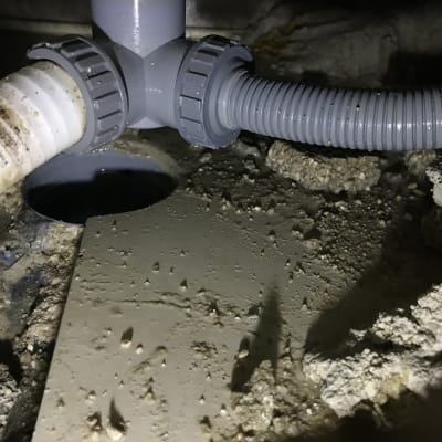 צינורות פלסטיק מחוברים במערכת ניקוז מתחת לכיור