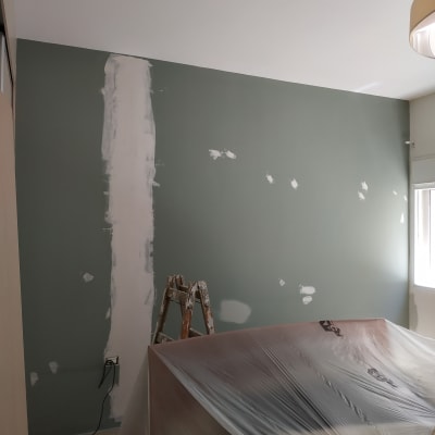 קיר צבוע חלקית עם סולם ויריעת פלסטיק