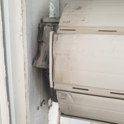 תריס גלילה לבן עם לכלוך ושחיקה