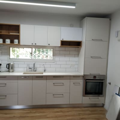 מטבח מודרני עם ארונות לבנים, תנור וכיור