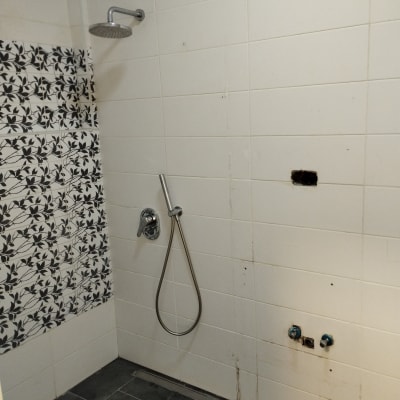 מקלחת עם אריחים לבנים ושחורים, חור בקיר