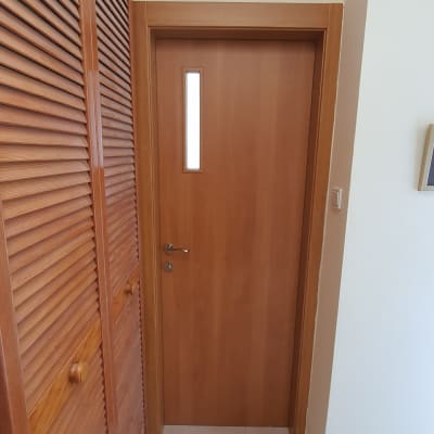 דלת עץ עם חלון קטן וידית מתכת