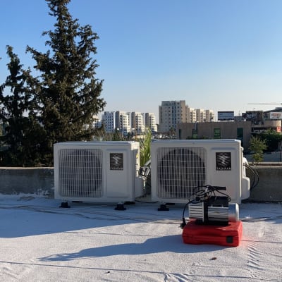 שני מזגנים על גג עם מכשיר על אדום