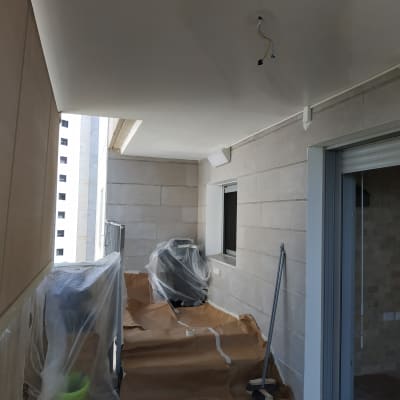 מרפסת עם ציוד לצביעה, דלי צבע ומברשת