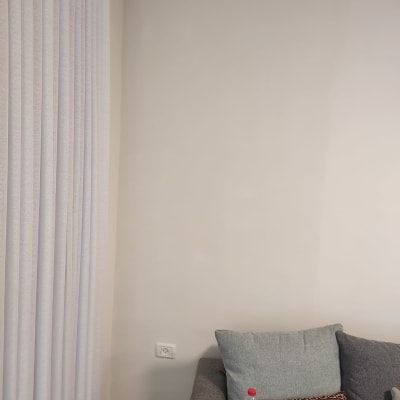 שקע חשמל על קיר לבן ליד וילון