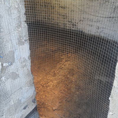 רשת מתכת מותקנת על פתח קיר למניעת כניסת יונים