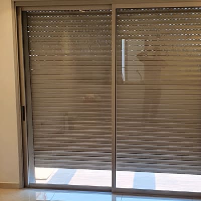 תריסים סגורים על חלון זכוכית גדול