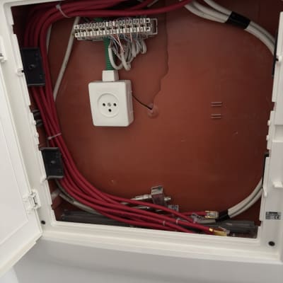 ארון תקשורת עם כבלים אדומים ולבנים מחוברים