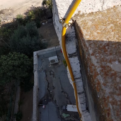 צינור צהוב מחובר לקיר עם תפסנים