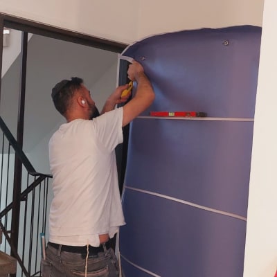 אדם מתקין ציפוי דלת בעזרת כלי עבודה