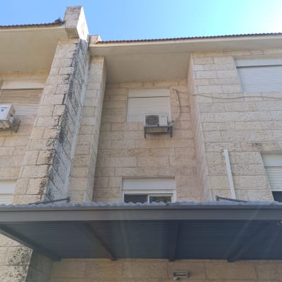 יחידת מיזוג אוויר מותקנת על קיר אבן חיצוני