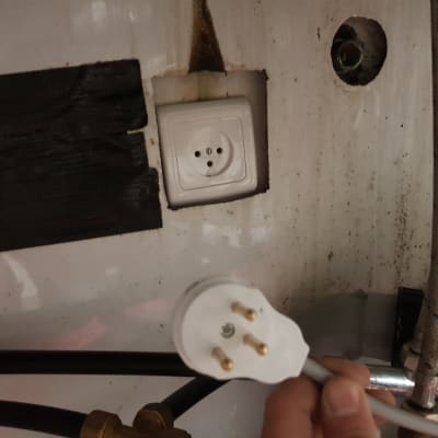 תקע חשמלי תלת פאזי ושקע על קיר לבן