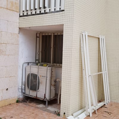 מסגרת אלומיניום לבנה מונחת על הרצפה ליד קיר