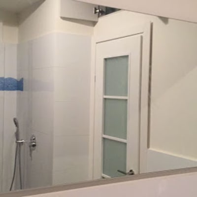 מראה גדולה על קיר חדר אמבטיה