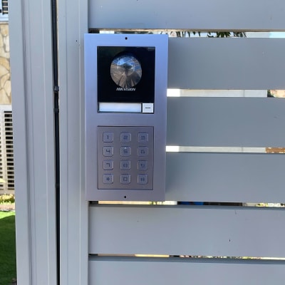 אינטרקום עם לוח מקשים ומצלמה מותקן על קיר
