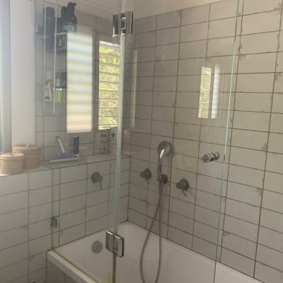 מקלחת עם ראש מקלחת, אמבטיה ודלת זכוכית