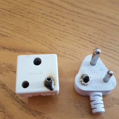 תקע ושקע חשמל שרופים על שולחן עץ