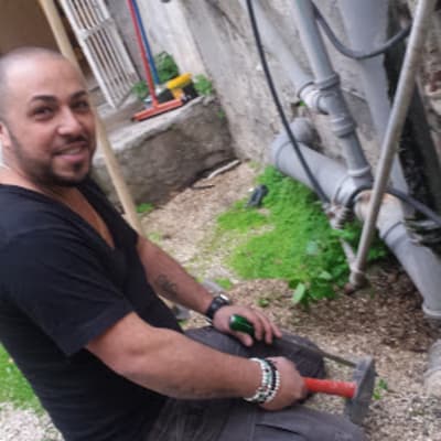 אדם מחזיק כלי עבודה ליד צינורות חיצוניים