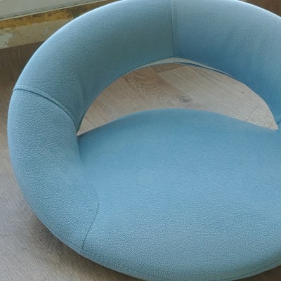 כרית עגולה מרופדת בצבע תכלת על שולחן עץ