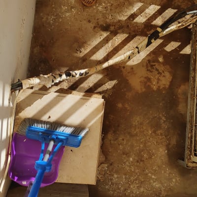 מטאטא כחול ויעה סגול על רצפה מלוכלכת