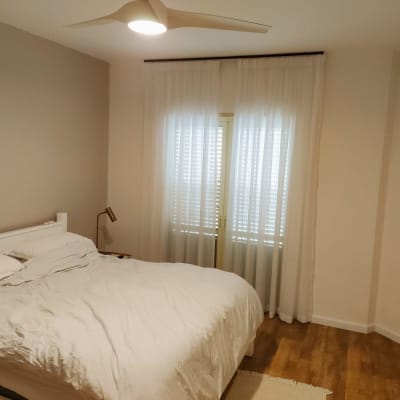 וילון לבן שקוף תלוי על חלון בחדר שינה