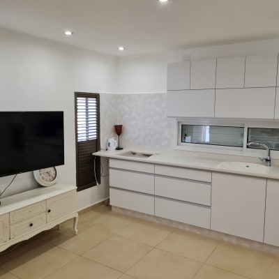 מטבח משופץ עם ארונות לבנים וכיור חדש