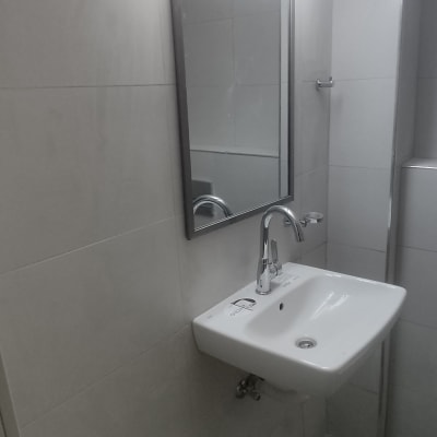 כיור חדש עם ברז ומראה מוארת בחדר אמבטיה