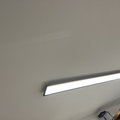 מנורת תקרה מלבנית מוארת על תקרה לבנה