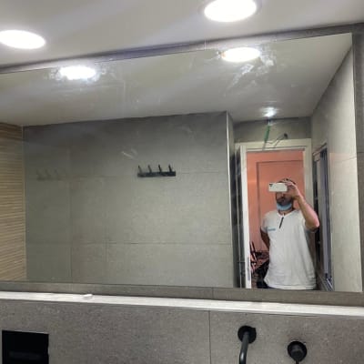 מראה גדולה עם מסגרת מתכת בחדר אמבטיה