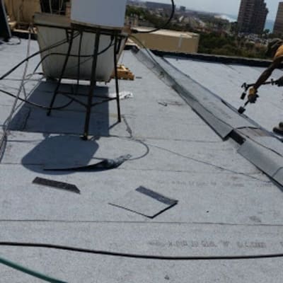 אדם עובד על איטום גג עם יריעות ביטומניות