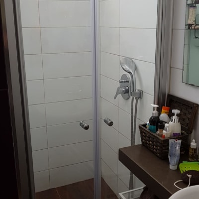 מקלחון עם דלתות זכוכית וברז מתכת