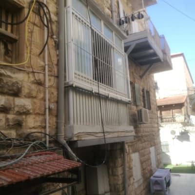 מסגרת מתכת סביב חלון במרפסת אבן