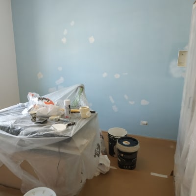 חדר צבוע בכחול עם כלים לצביעה על הרצפה