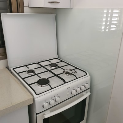 מגן זכוכית שקוף מאחורי כיריים במטבח