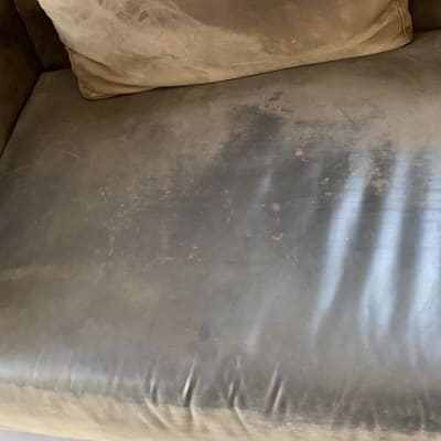 ספה מלוכלכת עם כתמים כהים על המושב