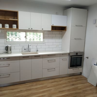 מטבח מודרני עם ארונות לבנים ותנור בילט אין