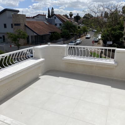 מרפסת נקייה עם רצפה בהירה ומעקה לבן