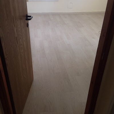 רצפת פרקט עץ בהירה בחדר עם דלת פתוחה