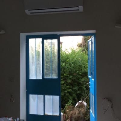 מזגן מותקן מעל דלתות כחולות פתוחות