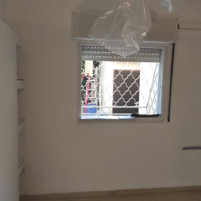 חדר עם קיר צבוע, חלון ופלסטיק תלוי