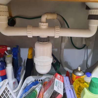 צנרת פלסטיק מתחת לכיור עם מסנן מים