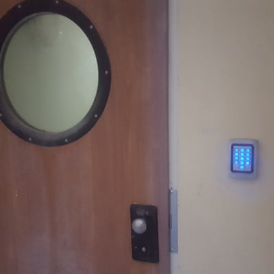 לוח מקשים מואר ליד דלת עץ