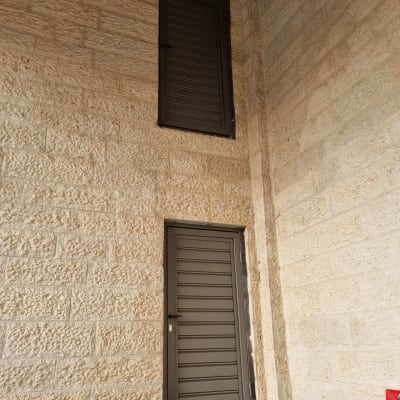 שתי דלתות מתכת אפורות על קיר אבן