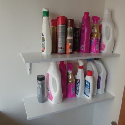 מדפים עם בקבוקי חומרי ניקוי שונים