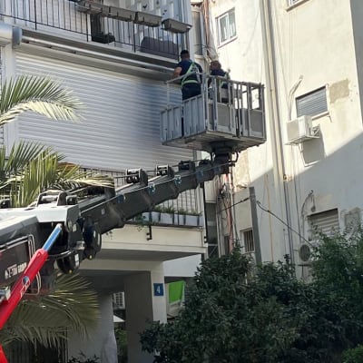 שני אנשים על מנוף מתקנים תריסים חיצוניים