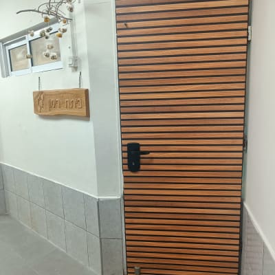 דלת עץ עם ידית שחורה וציפוי פסים אופקיים