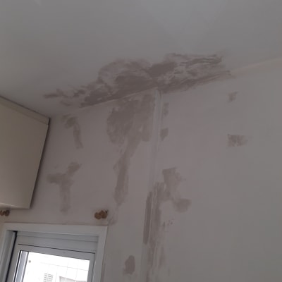 קיר ותקרה עם סימני רטיבות ותיקוני צבע
