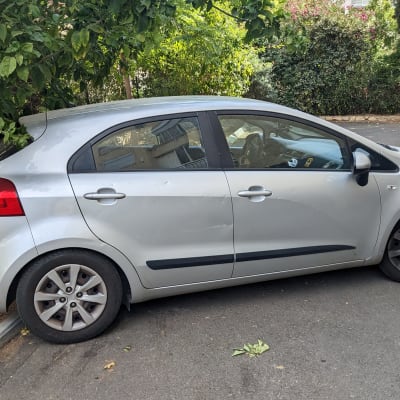 מכונית חונה על שפת המדרכה ליד עץ