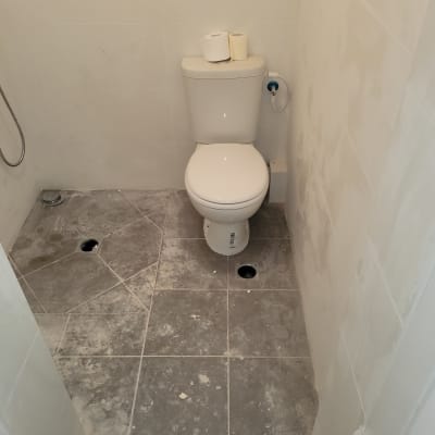 שירותים עם רצפה מלוכלכת באבק ולכלוך