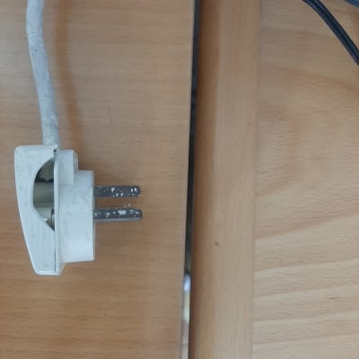 תקע חשמלי לבן עם כבל על שולחן עץ